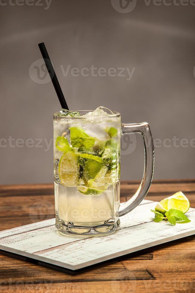 Refreshing Classic Mojito Soda with Lime and Mint served in mug isolated on wooden table side view of cold beverages drink photo