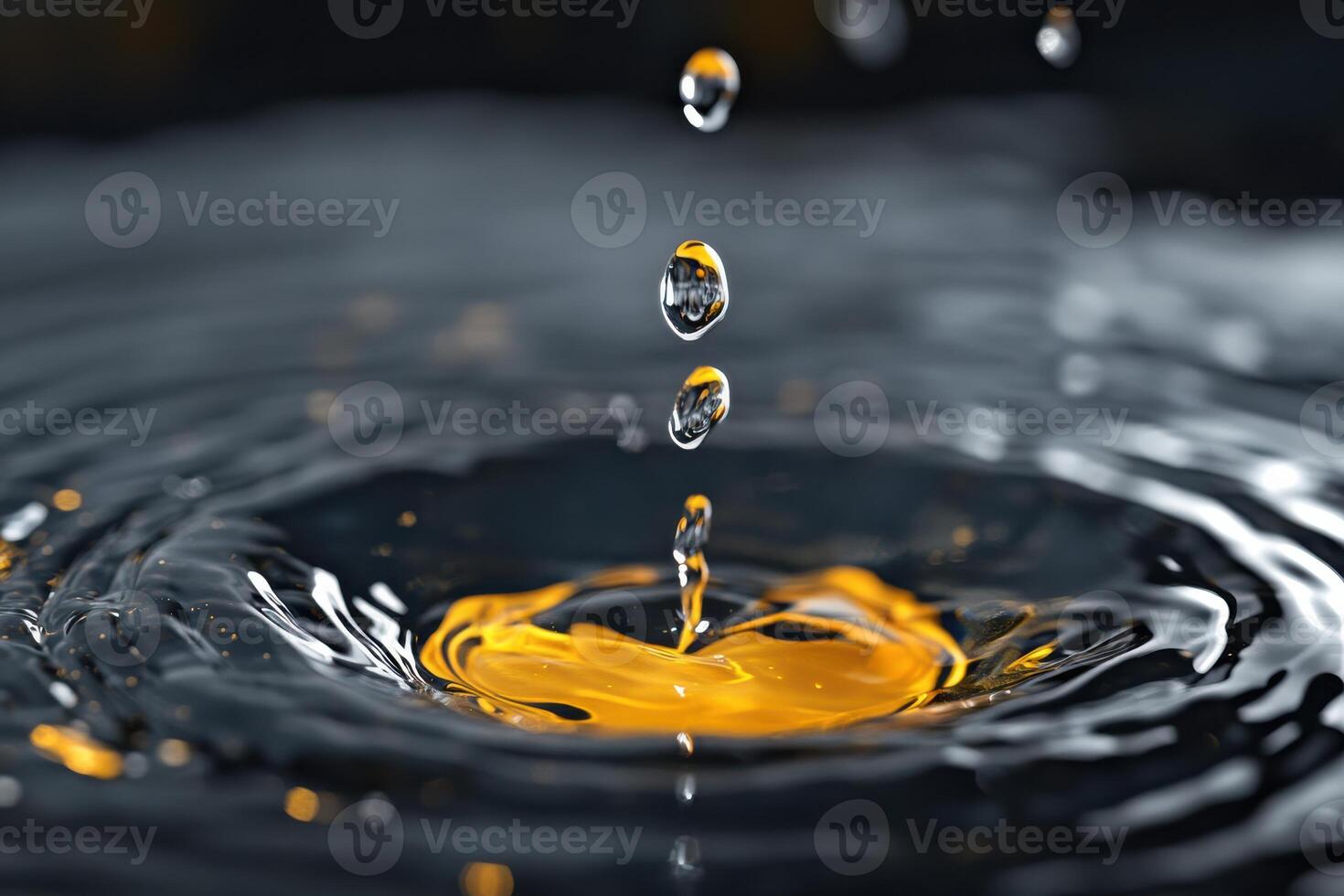 Water droplets create ripples in vibrant yellow liquid against a dark background photo