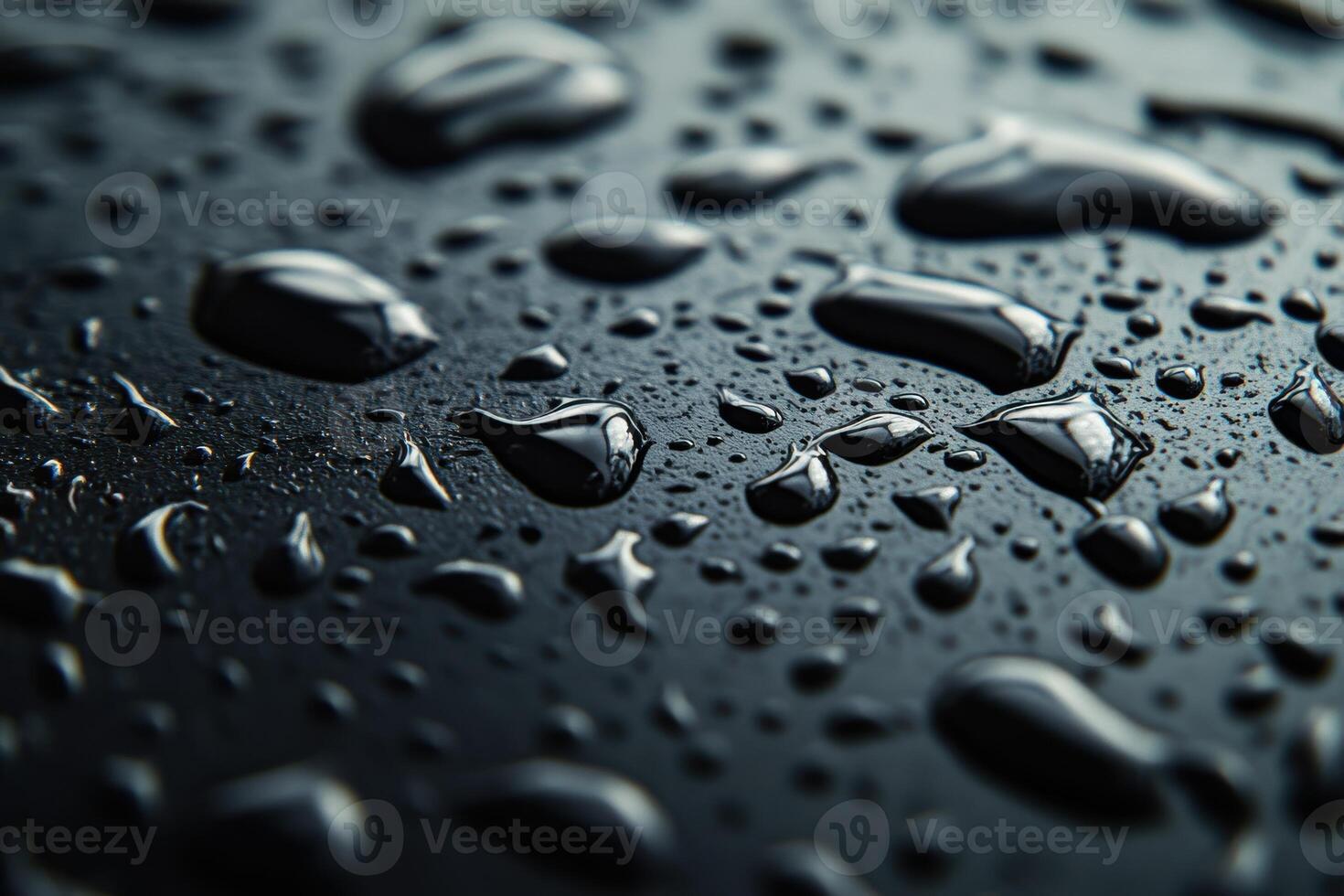 Droplets of water clustered on a dark surface after a heavy rain shower in the evening photo
