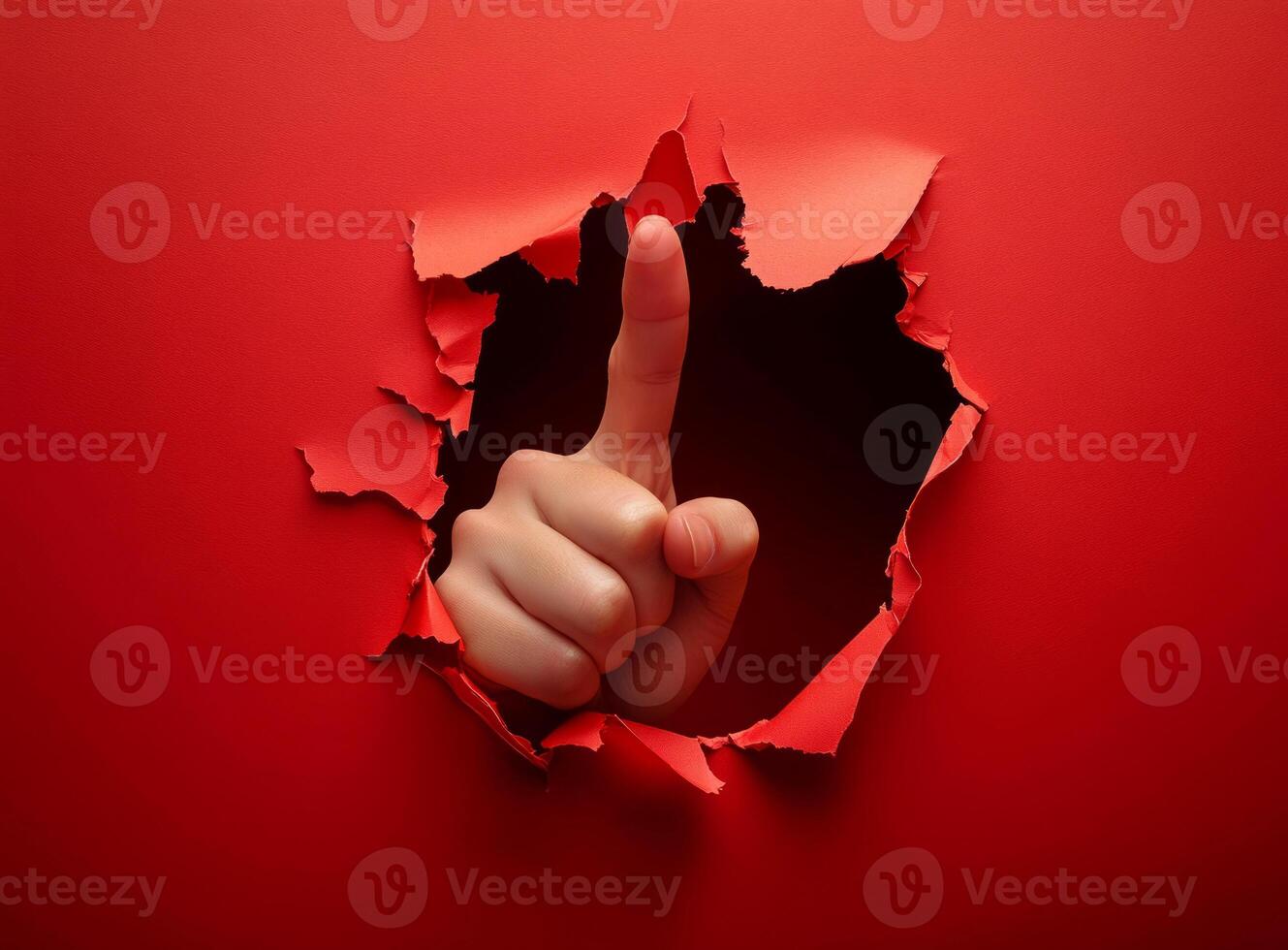 photo of a hand with a raised thumb peeking out of a torn red paper.