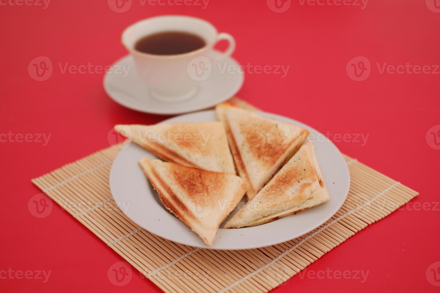 Toasted bread on a white plate isolated on a red background. photo