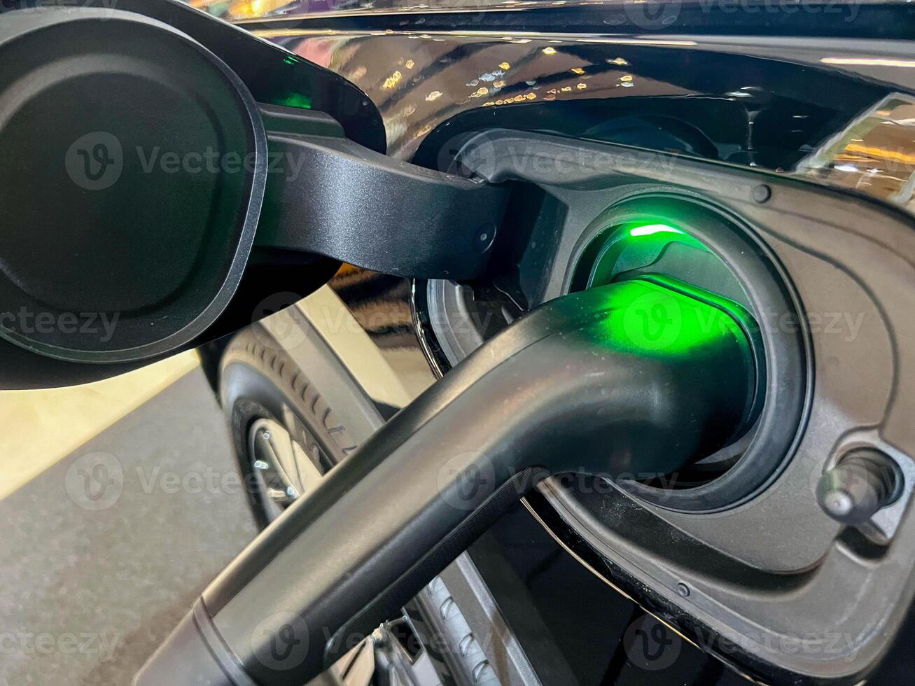 Closeup electric plug charging to EV car at at Electric vehicle charging station photo