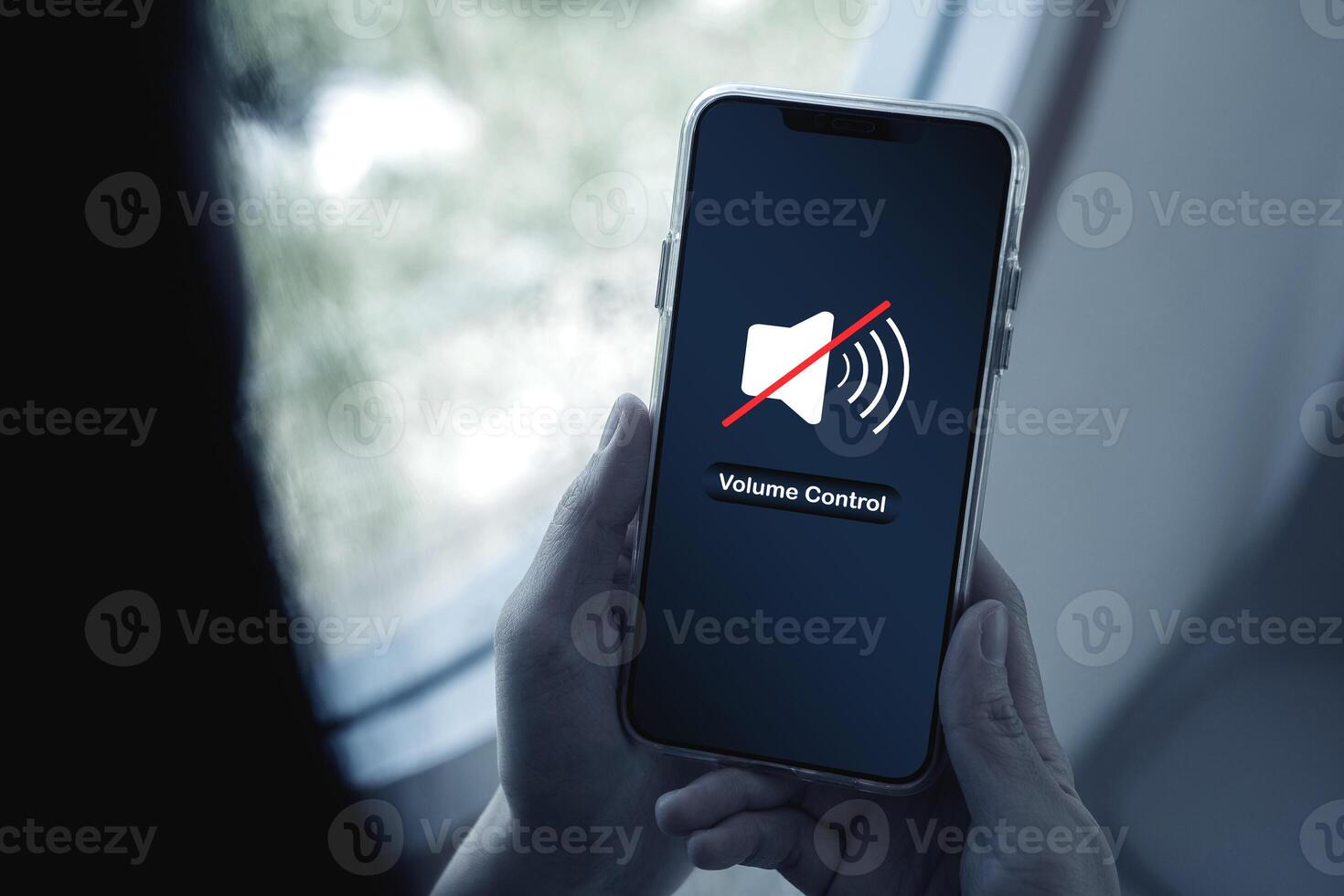 Close-up view of Hand pressing volume of smartphone in silent or mute mode activated. photo