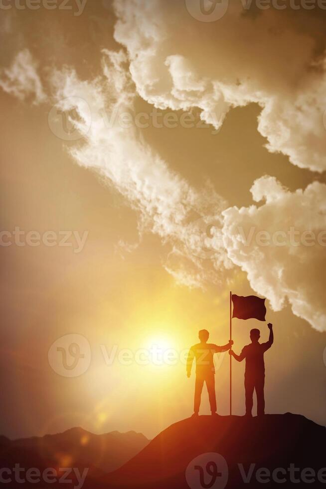 Business success, leadership, and goal concepts. Silhouette of vertical businessman with flags on mountain peaks above sky and sunset background. photo