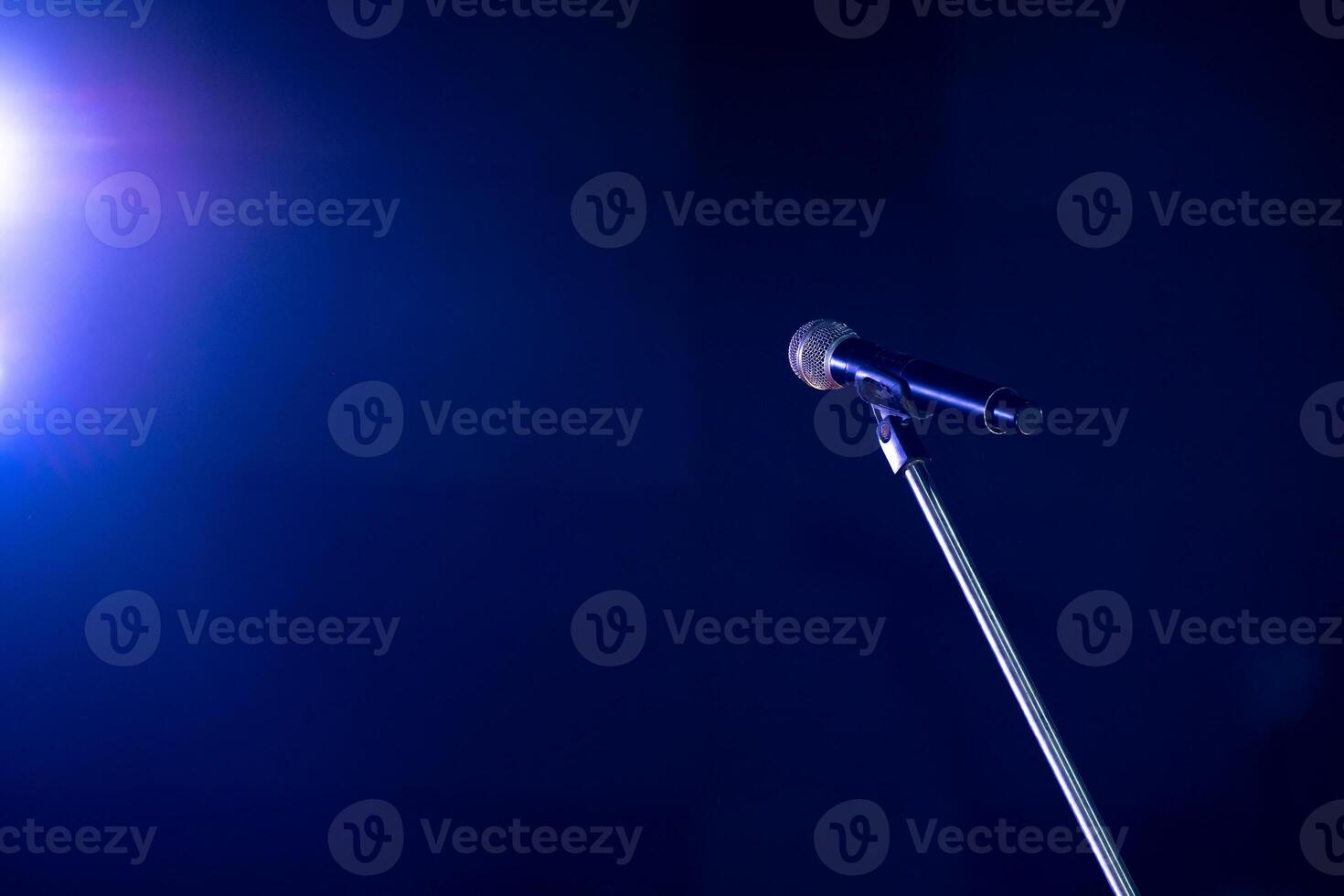 Close-up the microphone on stand for speaker speech at seminar room with blue light background and blur bokeh, Presentation microphone on a stand, Copy space photo
