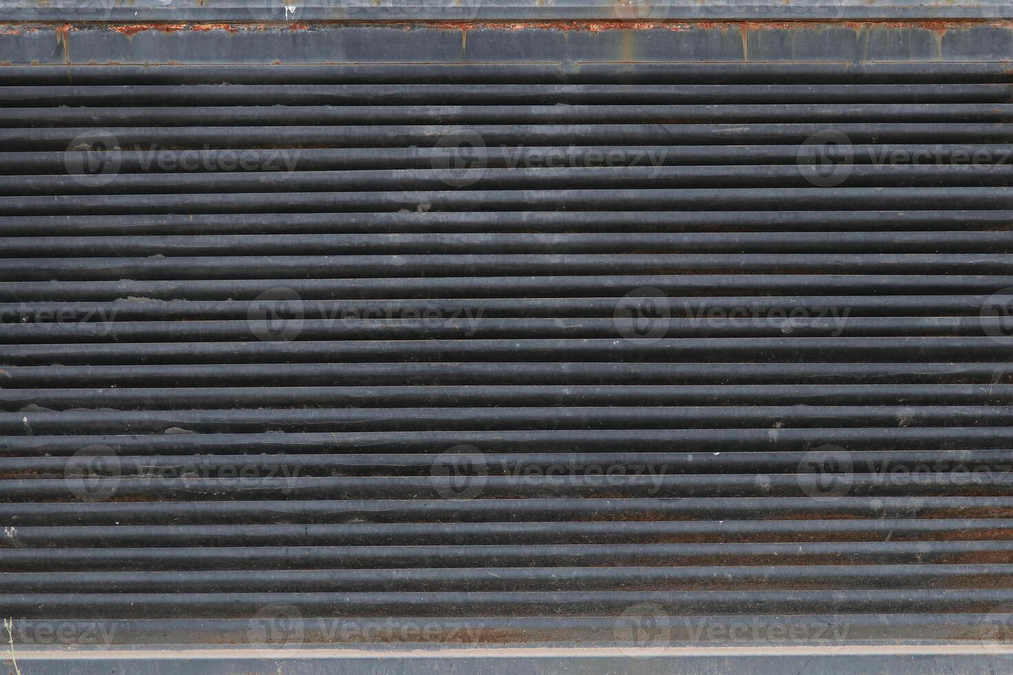 A part of an old and rusted door with a metal surface photo