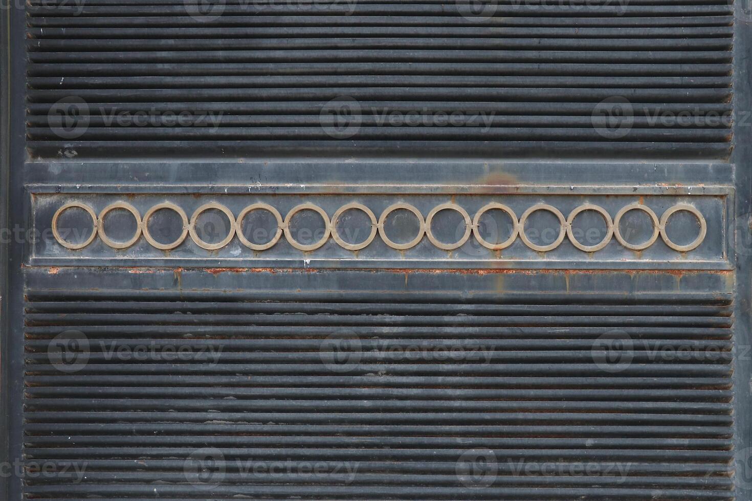 A part of an old and rusted door with a metal surface photo