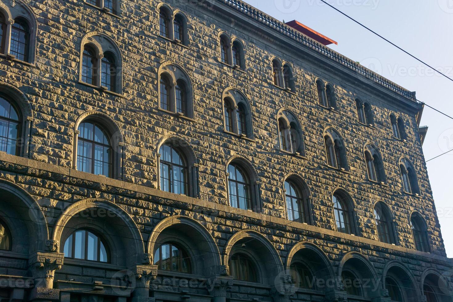architectural background, dark facade of an old city building, barely illuminated by the morning sun rays photo
