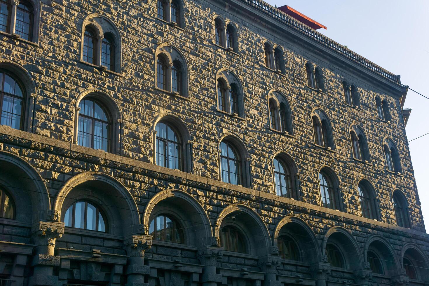architectural background, dark facade of an old city building, barely illuminated by the morning sun rays photo