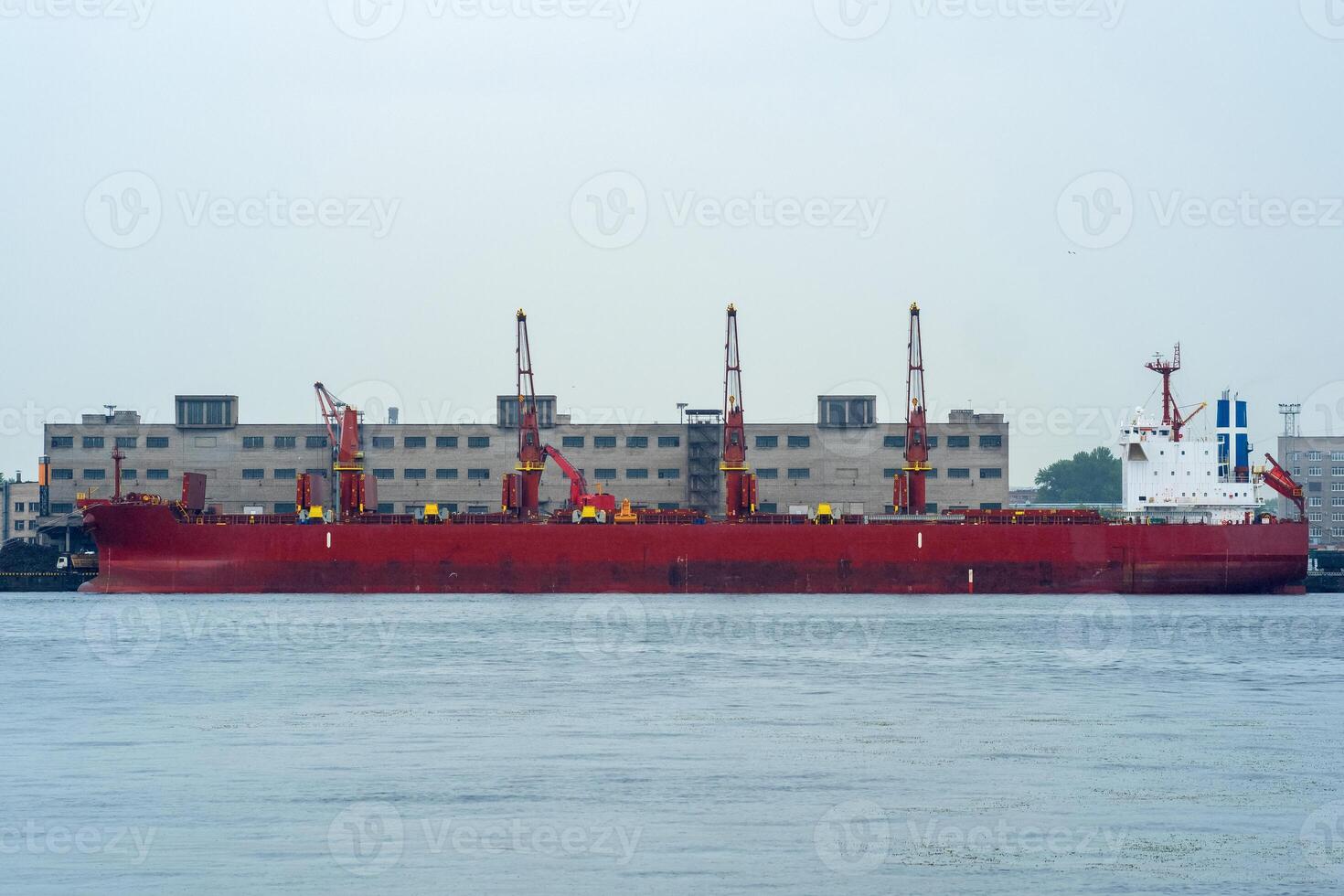 bulk carrier ship in a cargo port on a cloudy day photo