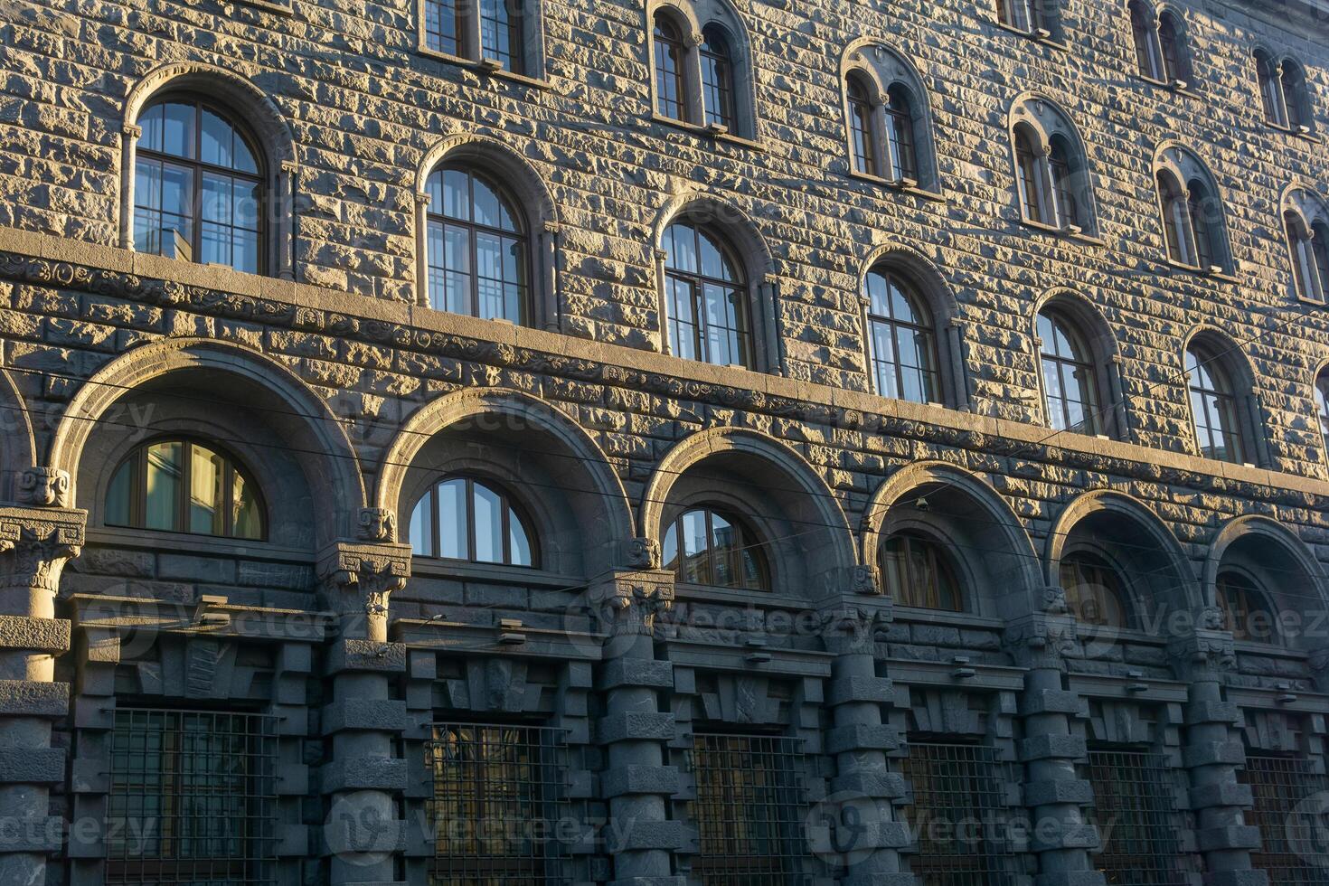 architectural background, dark facade of an old city building, barely illuminated by the morning sun rays photo