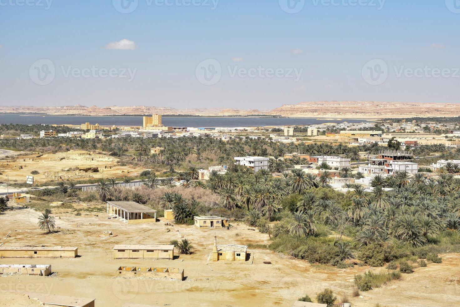 lanscape view of siwa egypt with date palm groves, oasis and vast desert from above the mountain of the dead at sunny day photo