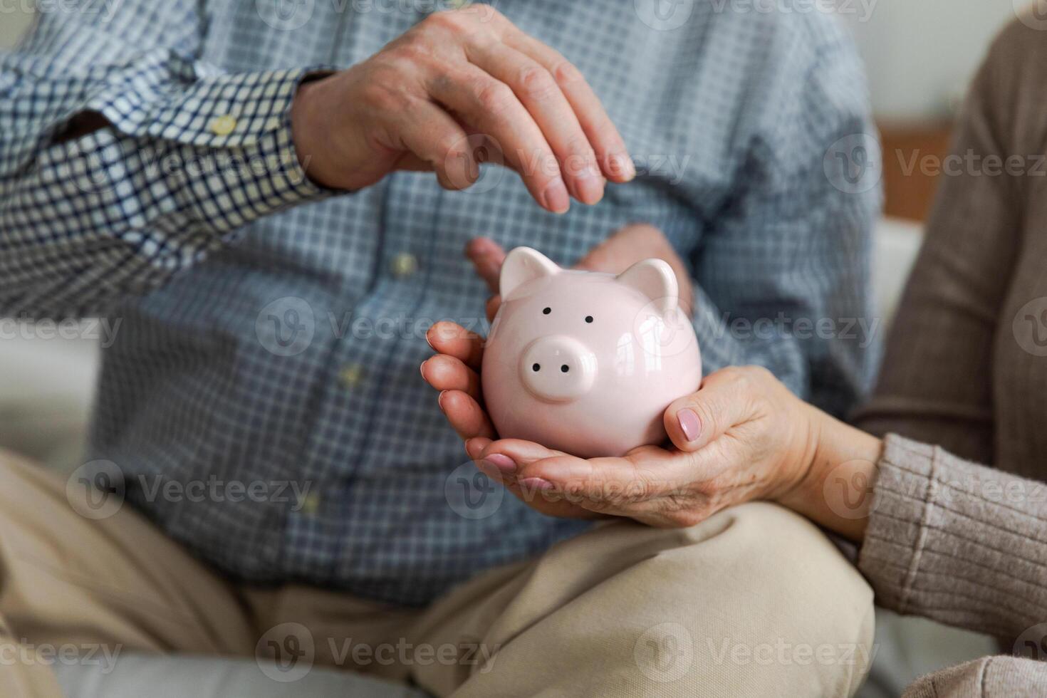 Saving money investment for future. Senior adult mature couple hands putting money coin in piggy bank. Old man woman counting saving money planning retirement budget. Saving investment banking concept photo