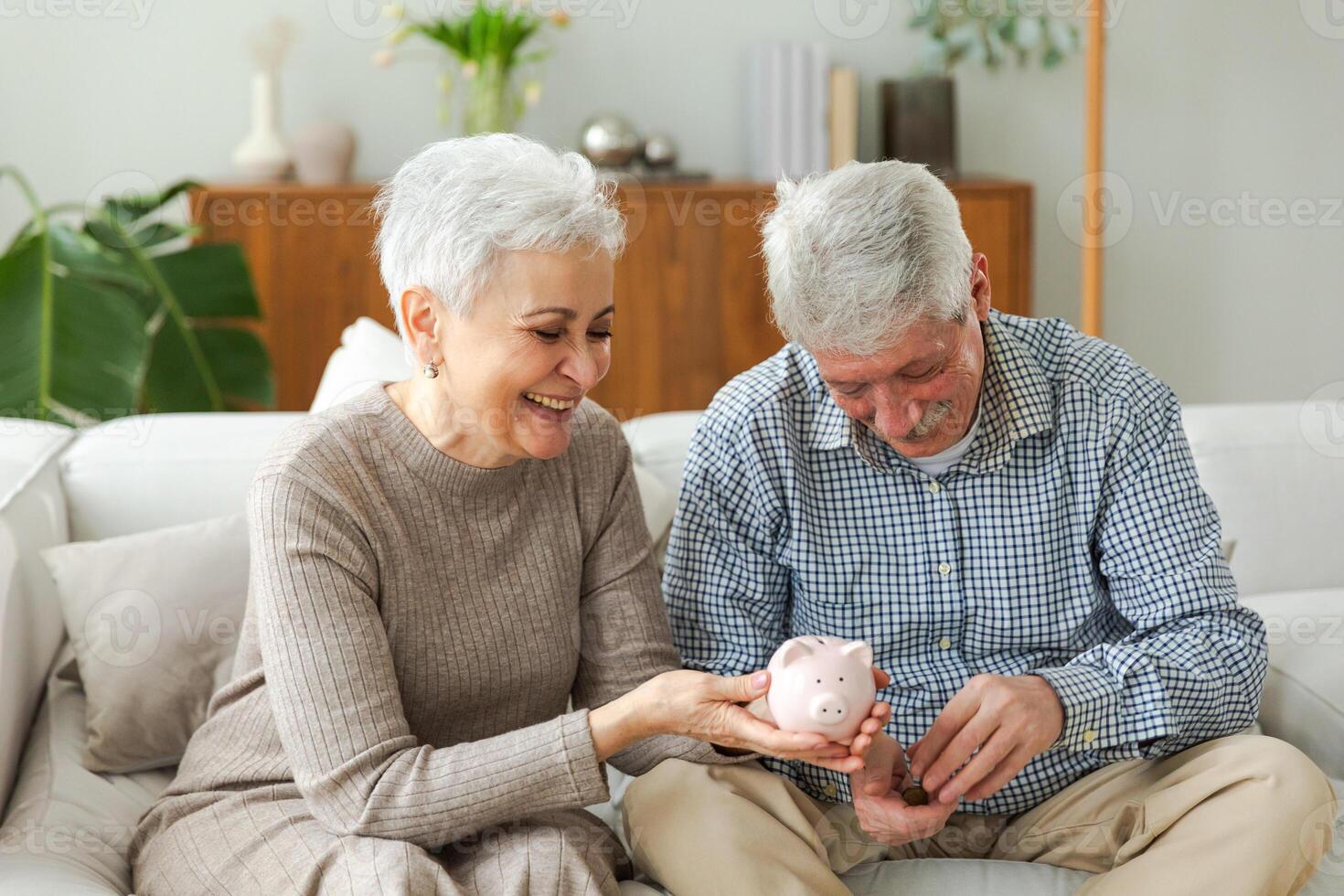 Saving money investment for future. Senior adult mature couple holding piggy bank putting money coin. Old man woman counting saving money planning retirement budget. Saving investment banking concept photo