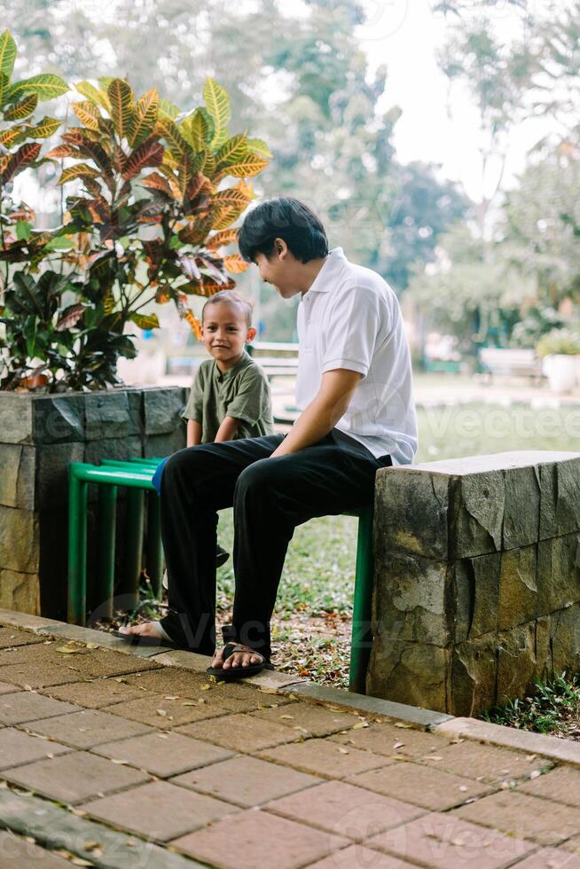 A father and his child sitting and chatting in a city square photo