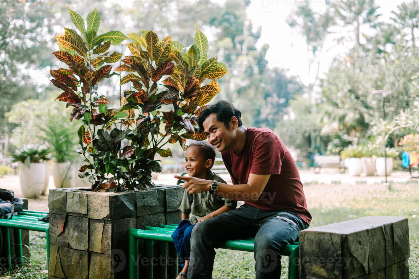 A father and his child sitting and chatting in a city square photo