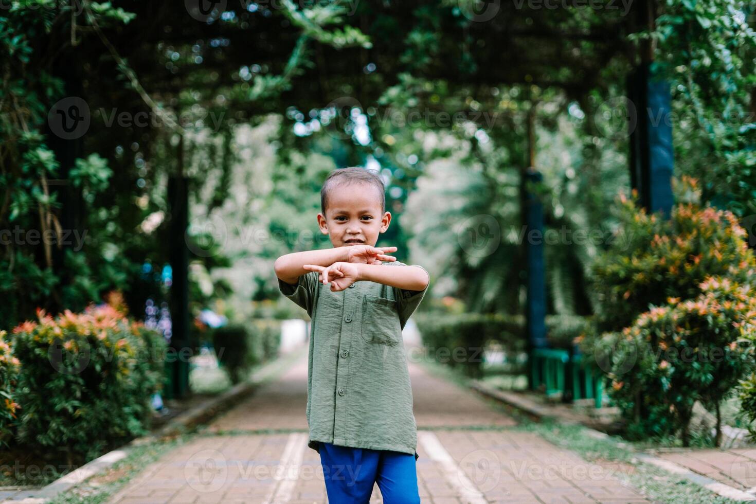A young Southeast Asian child showing the number two with their fingers, symbolizing peace or victory photo