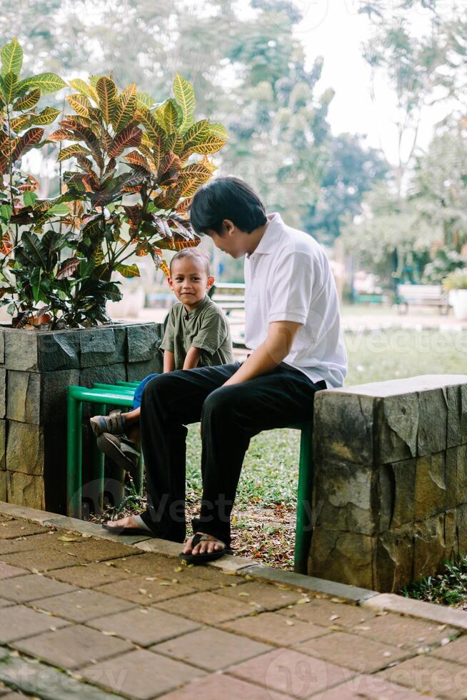 A father and his child sitting and chatting in a city square photo