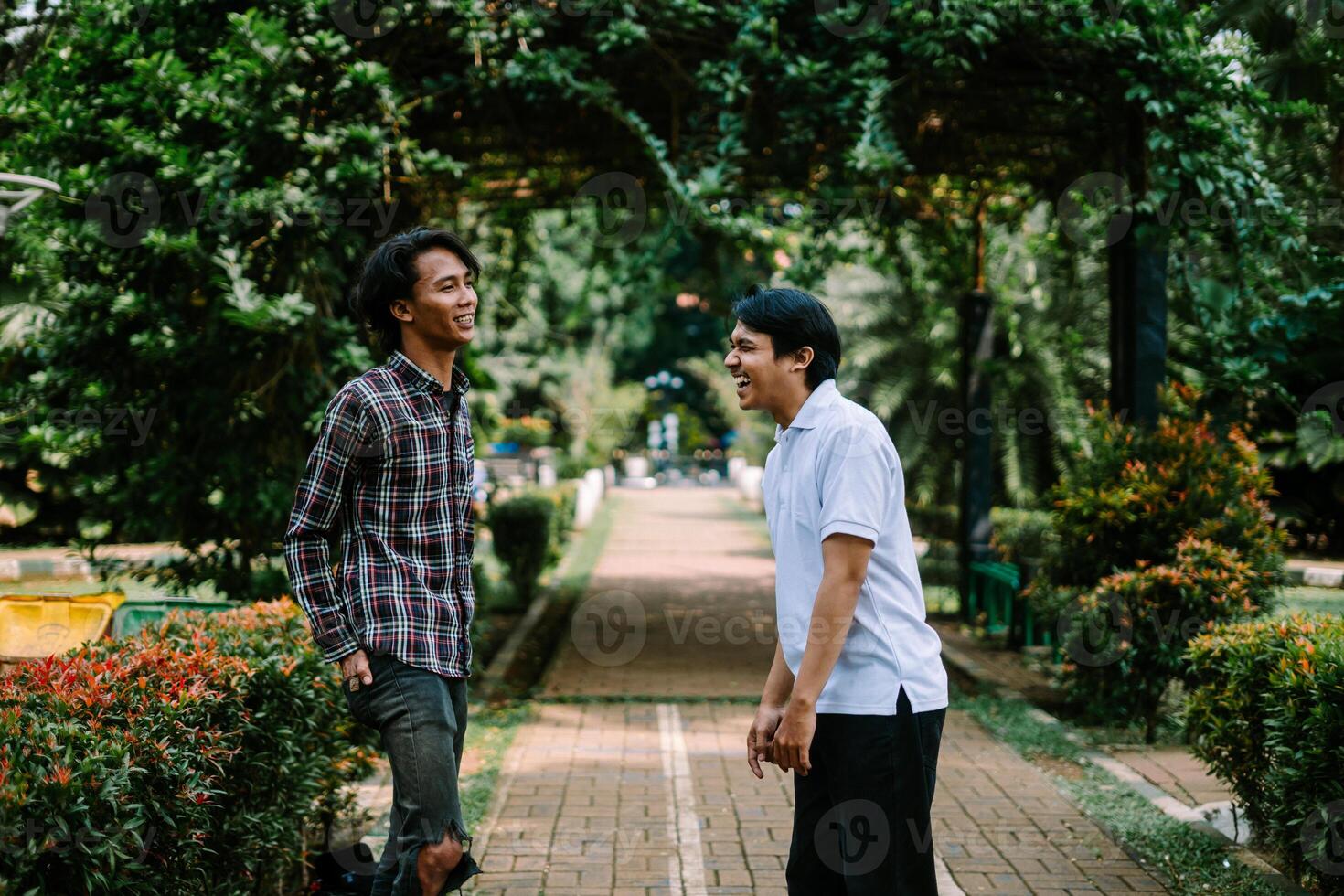 Two Southeast Asian men engaged in a lively conversation at a city square. photo