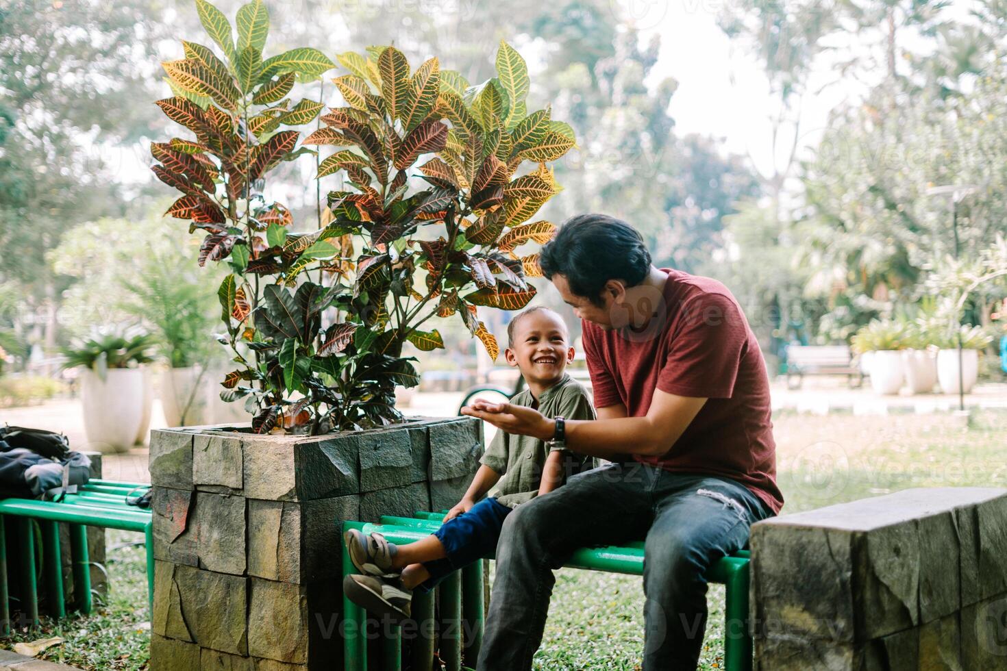A father and his child sitting and chatting in a city square photo