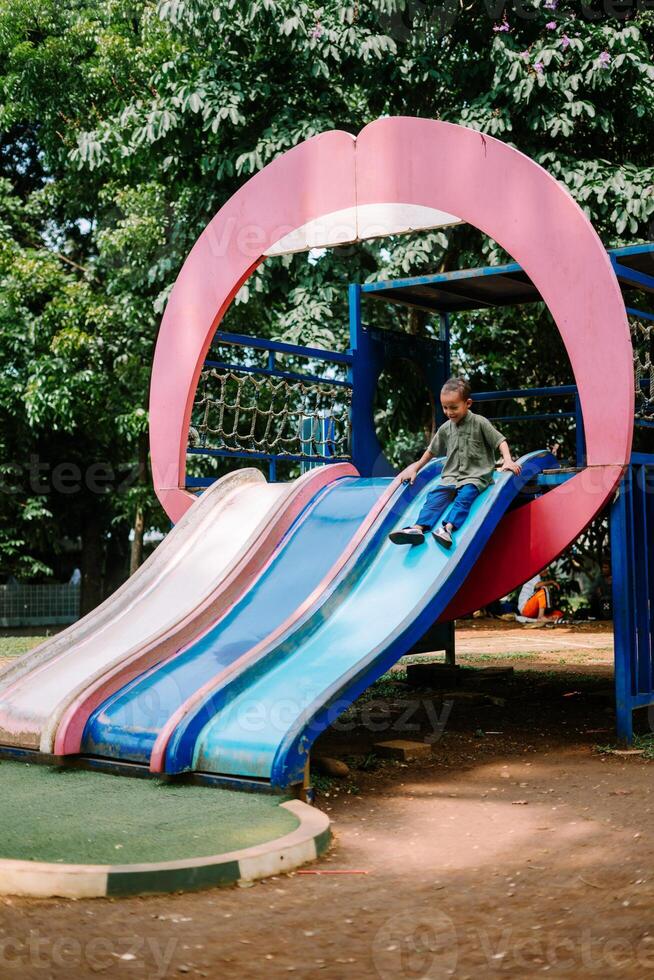 A child playing joyfully in a city playground, exploring swings and slides. photo