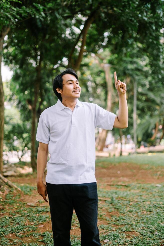 Southeast Asian man pointing at something, capturing a moment of focus or instruction. photo