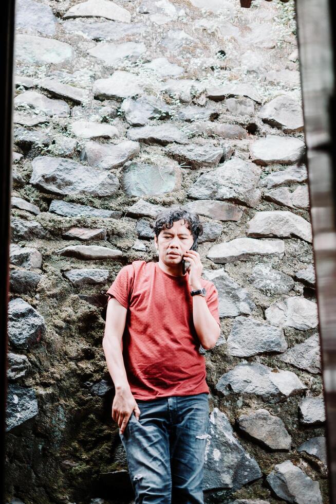 Southeast Asian man making a phone call, capturing a moment of communication and connection photo