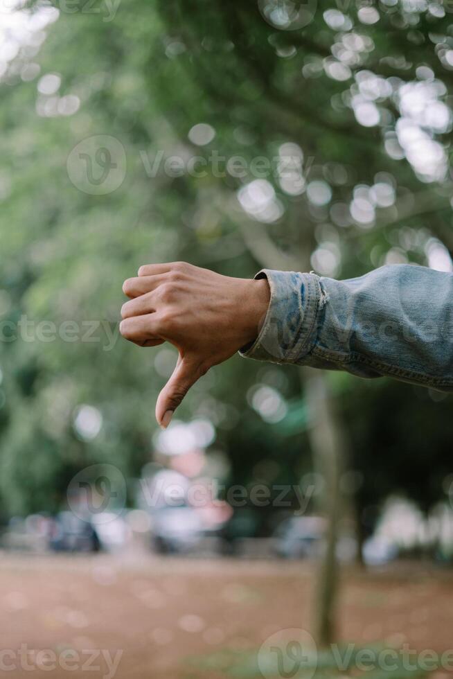Hand showing an upside-down thumb gesture, conveying disapproval or a playful attitude. photo