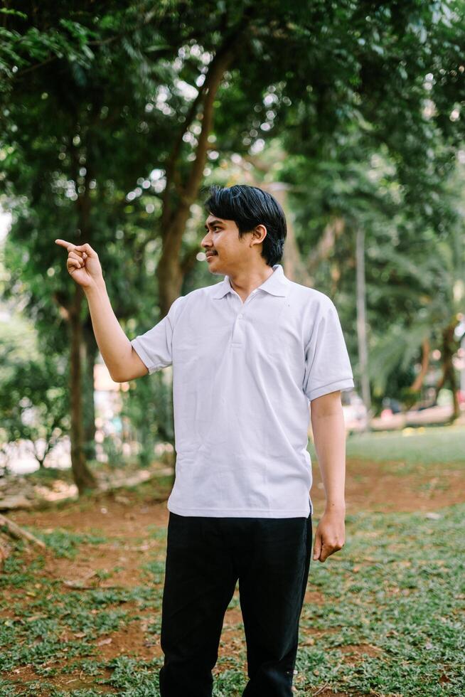 Southeast Asian man pointing at something, capturing a moment of focus or instruction. photo