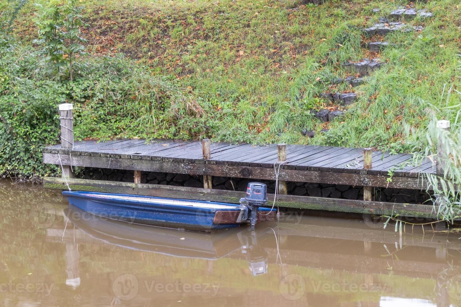 small blue boat on the wooden jetty photo