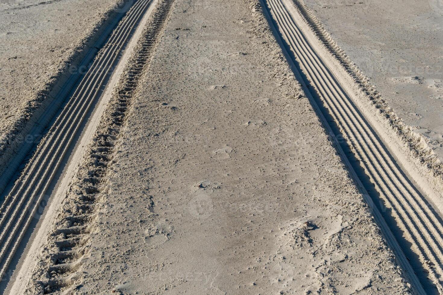 rough tire tracks on the north sea beach photo