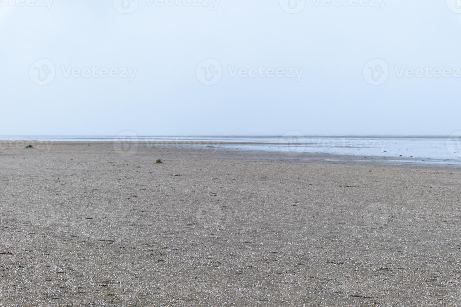 sandy beach in ouddorp, the netherlands, in bad cloudy autumn weather photo