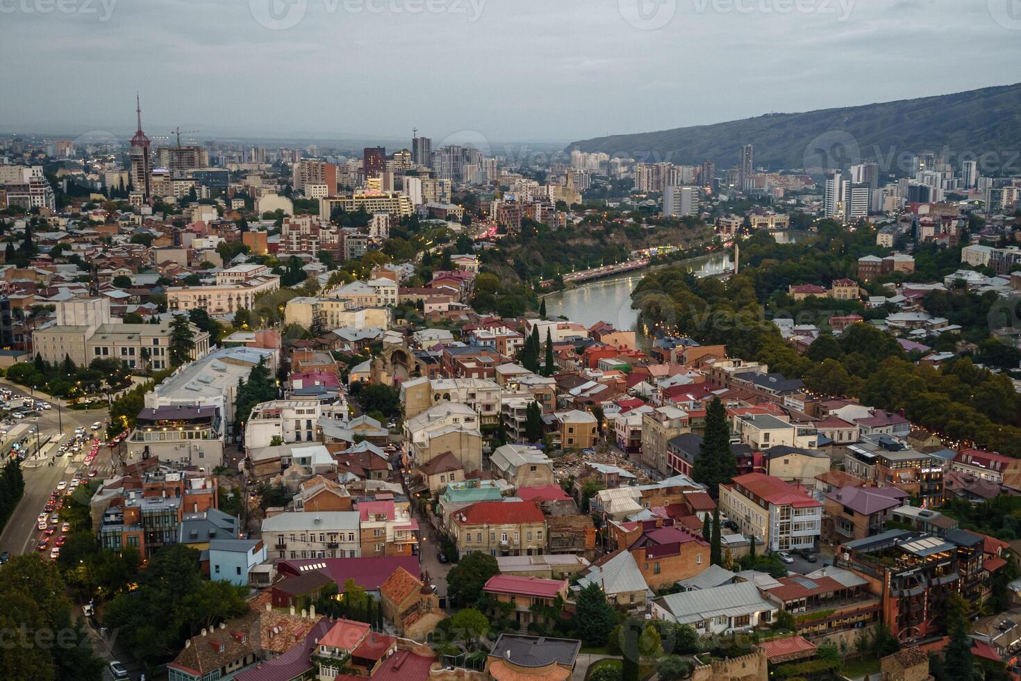 A stunning aerial view of Tbilisis vibrant city at dusk, blending historic and modern architecture photo