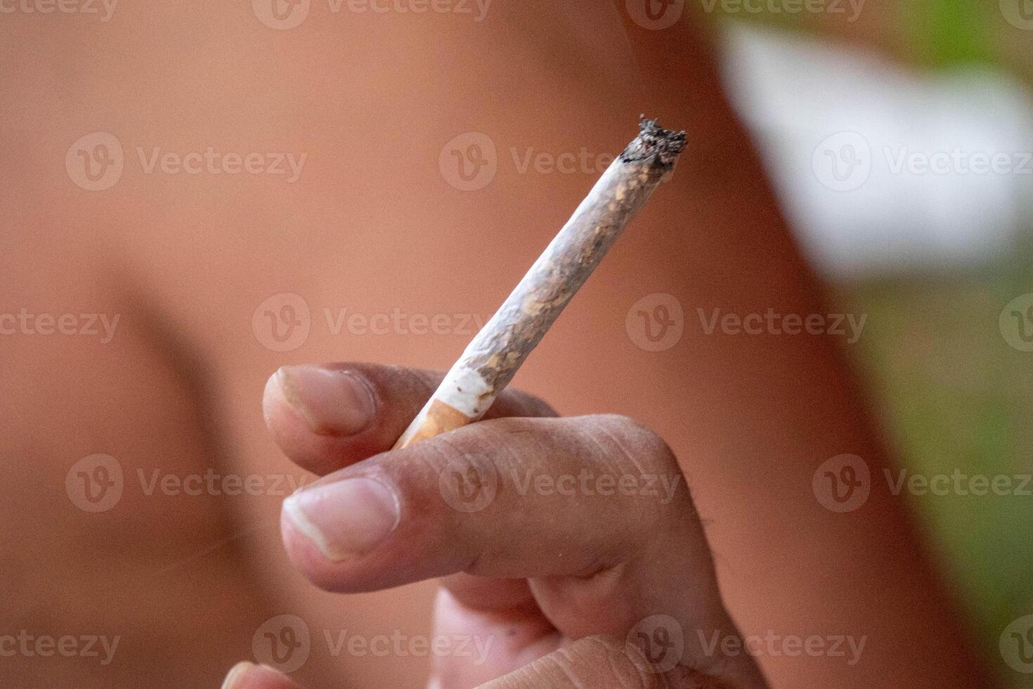 A person with a marijuana cigarette in his hand. photo
