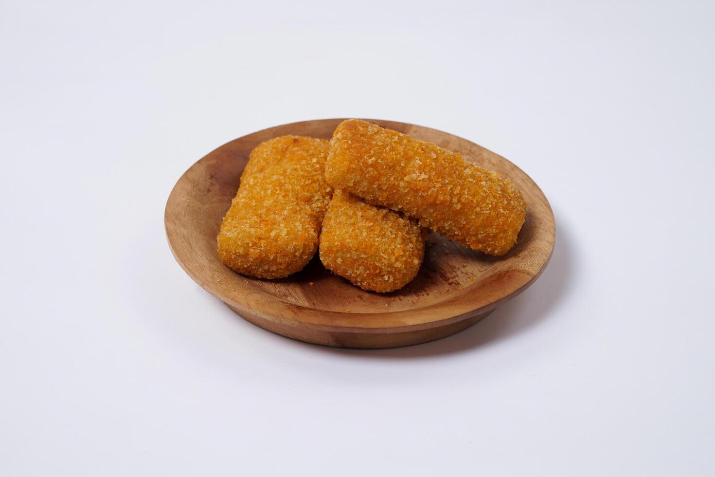 American Risoles or risoles mayo is a traditional Indonesian snack filled with smoked beef or sausage, boiled eggs and mayonnaise. Crispy texture on the outside. Risoles on wood plate isolated white. photo