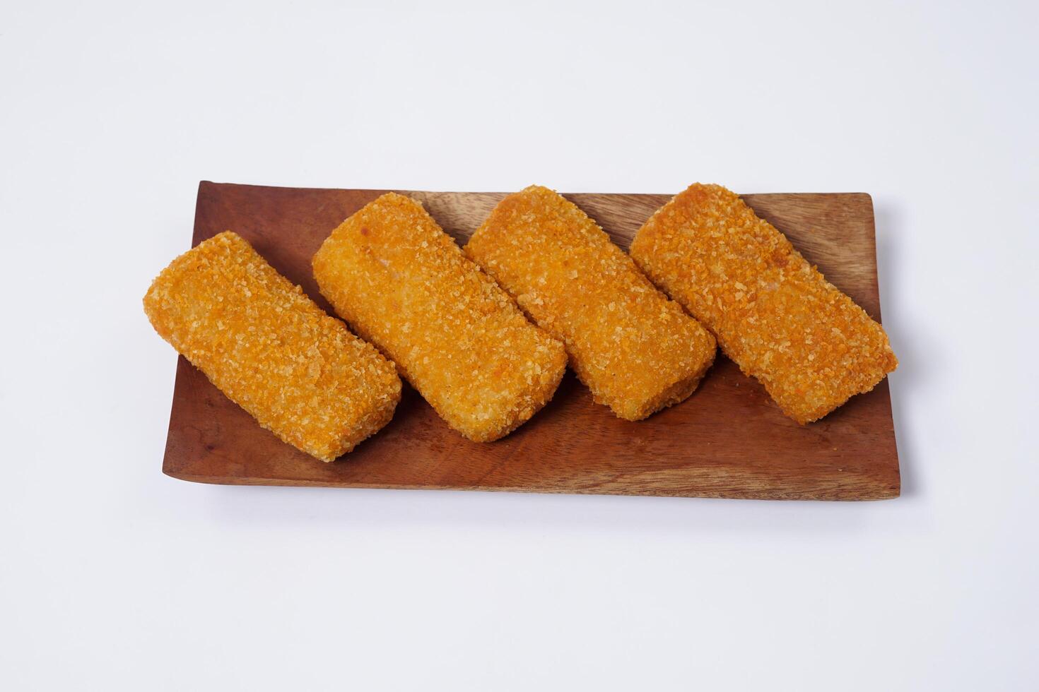 American Risoles or risoles mayo is a traditional Indonesian snack filled with smoked beef or sausage, boiled eggs and mayonnaise. Crispy texture on the outside. Risoles on wood plate isolated white. photo