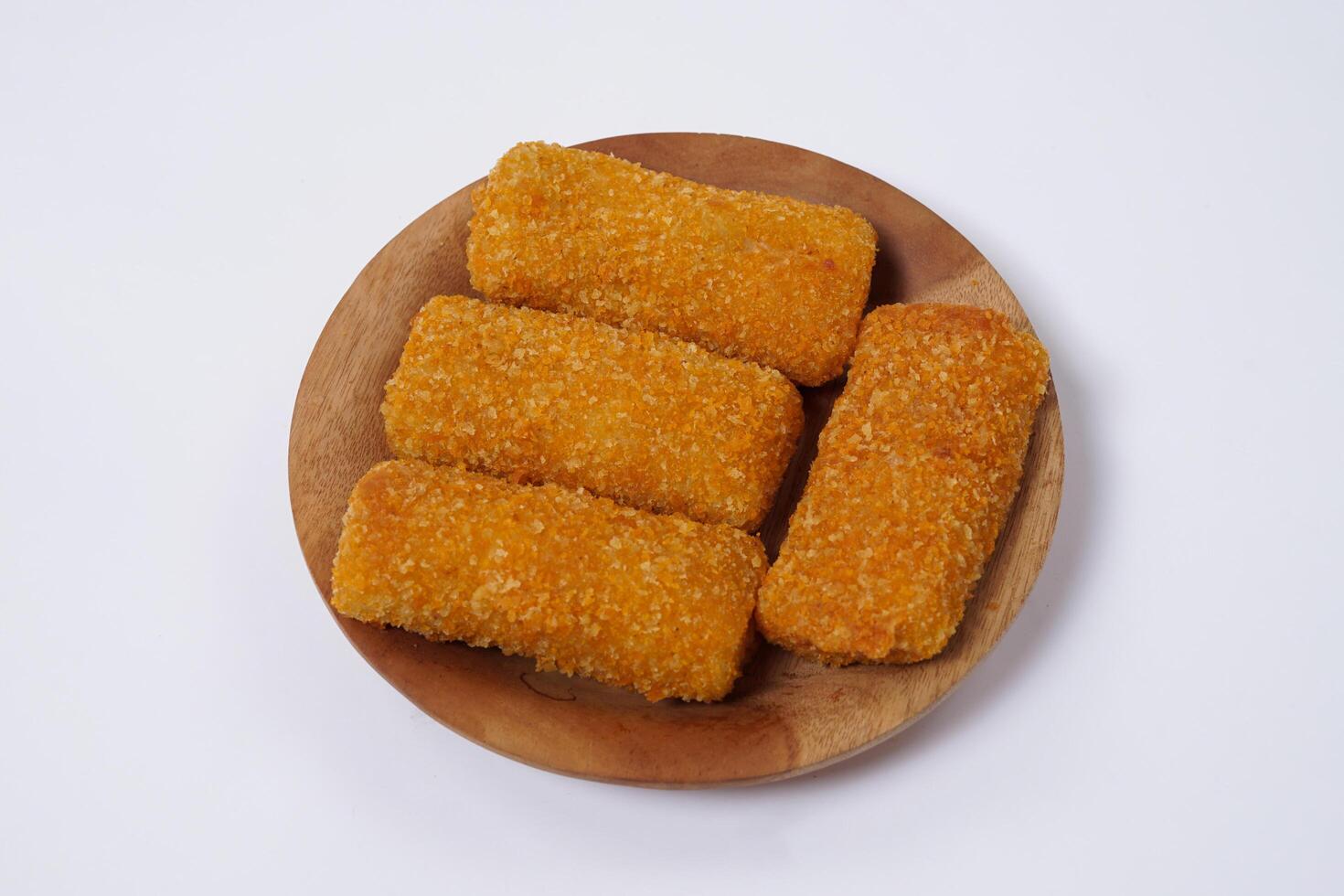 American Risoles or risoles mayo is a traditional Indonesian snack filled with smoked beef or sausage, boiled eggs and mayonnaise. Crispy texture on the outside. Risoles on wood plate isolated white. photo