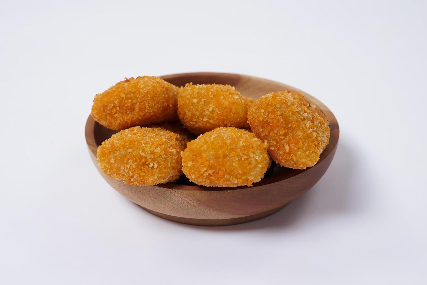 American Risoles or risoles mayo is a traditional Indonesian snack filled with smoked beef or sausage, boiled eggs and mayonnaise. Crispy texture on the outside. Risoles on wood plate isolated white. photo