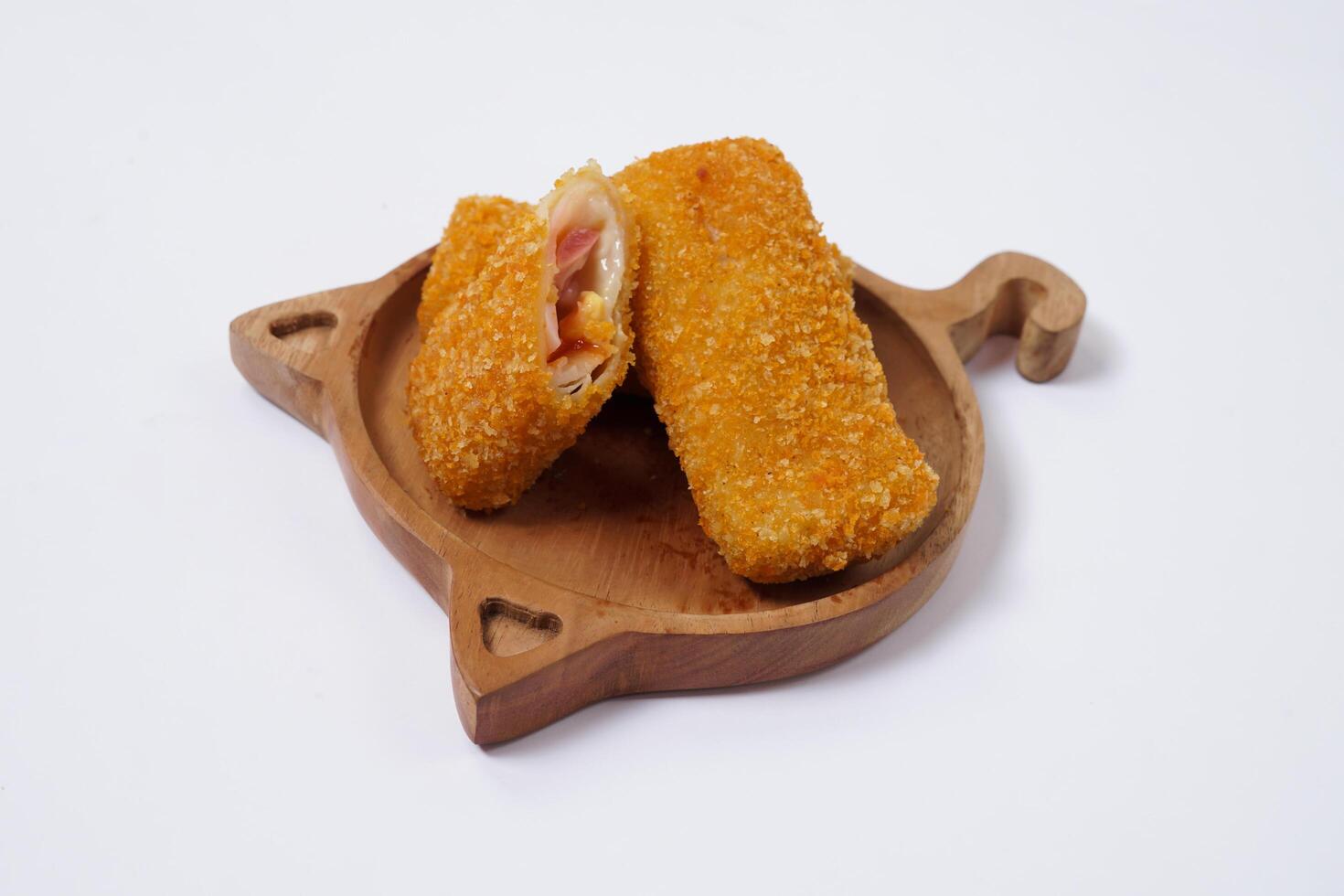 American Risoles or risoles mayo is a traditional Indonesian snack filled with smoked beef or sausage, boiled eggs and mayonnaise. Crispy texture on the outside. Risoles on wood plate isolated white. photo