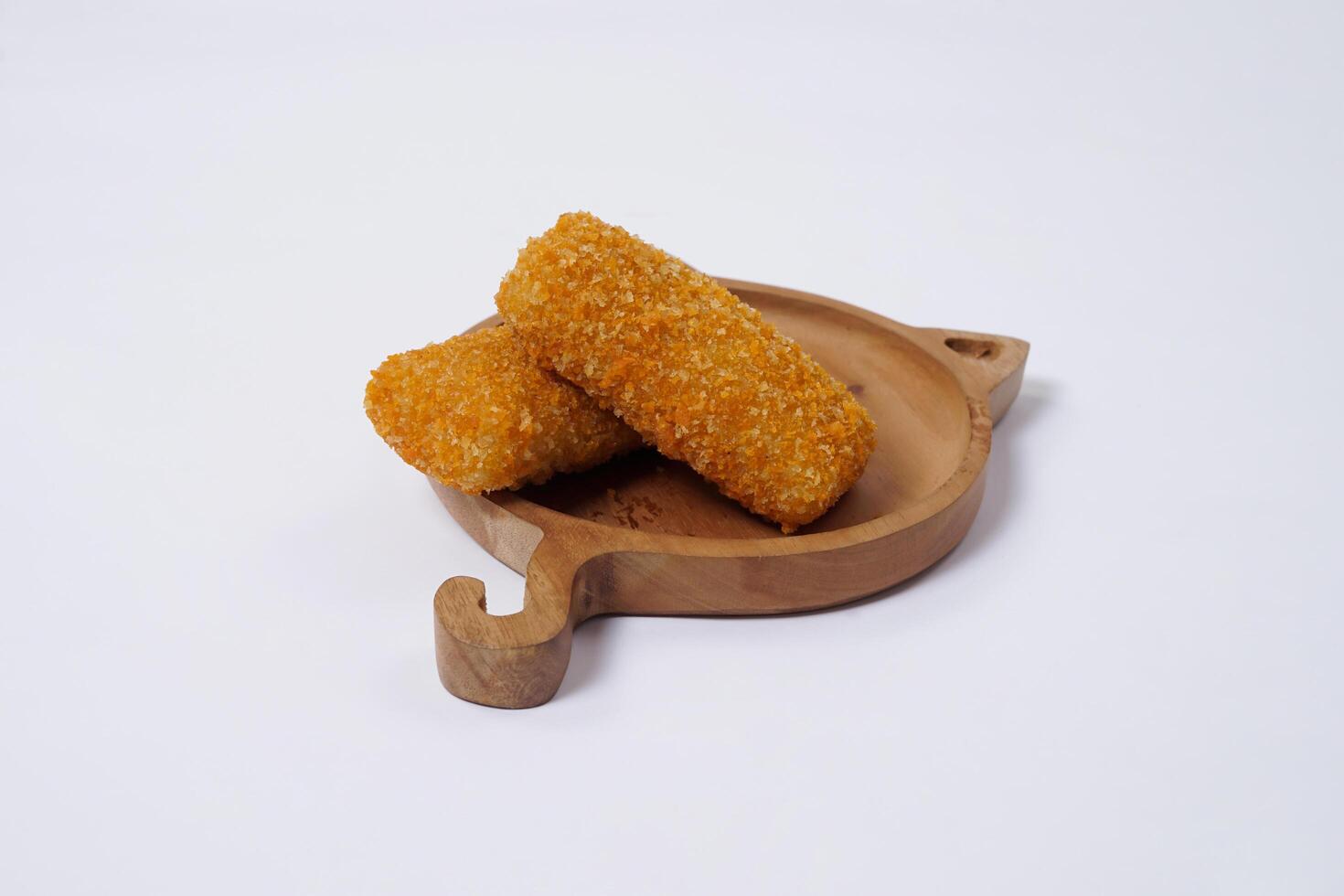 American Risoles or risoles mayo is a traditional Indonesian snack filled with smoked beef or sausage, boiled eggs and mayonnaise. Crispy texture on the outside. Risoles on wood plate isolated white. photo