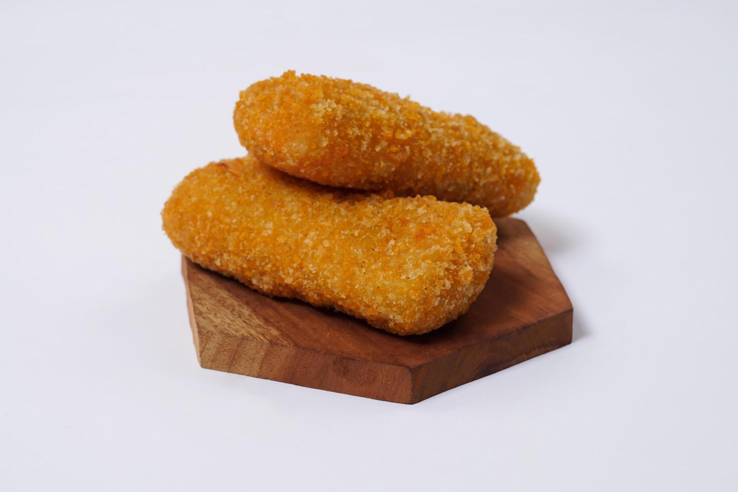 American Risoles or risoles mayo is a traditional Indonesian snack filled with smoked beef or sausage, boiled eggs and mayonnaise. Crispy texture on the outside. Risoles on wood plate isolated white. photo