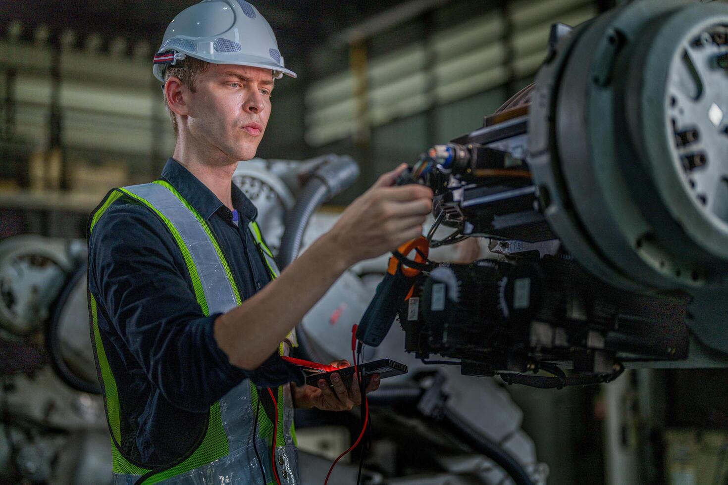 male engineer workers maintenance automatic robotic arm machine in a factory. worker checking and repairing automatic robot hand machine. photo