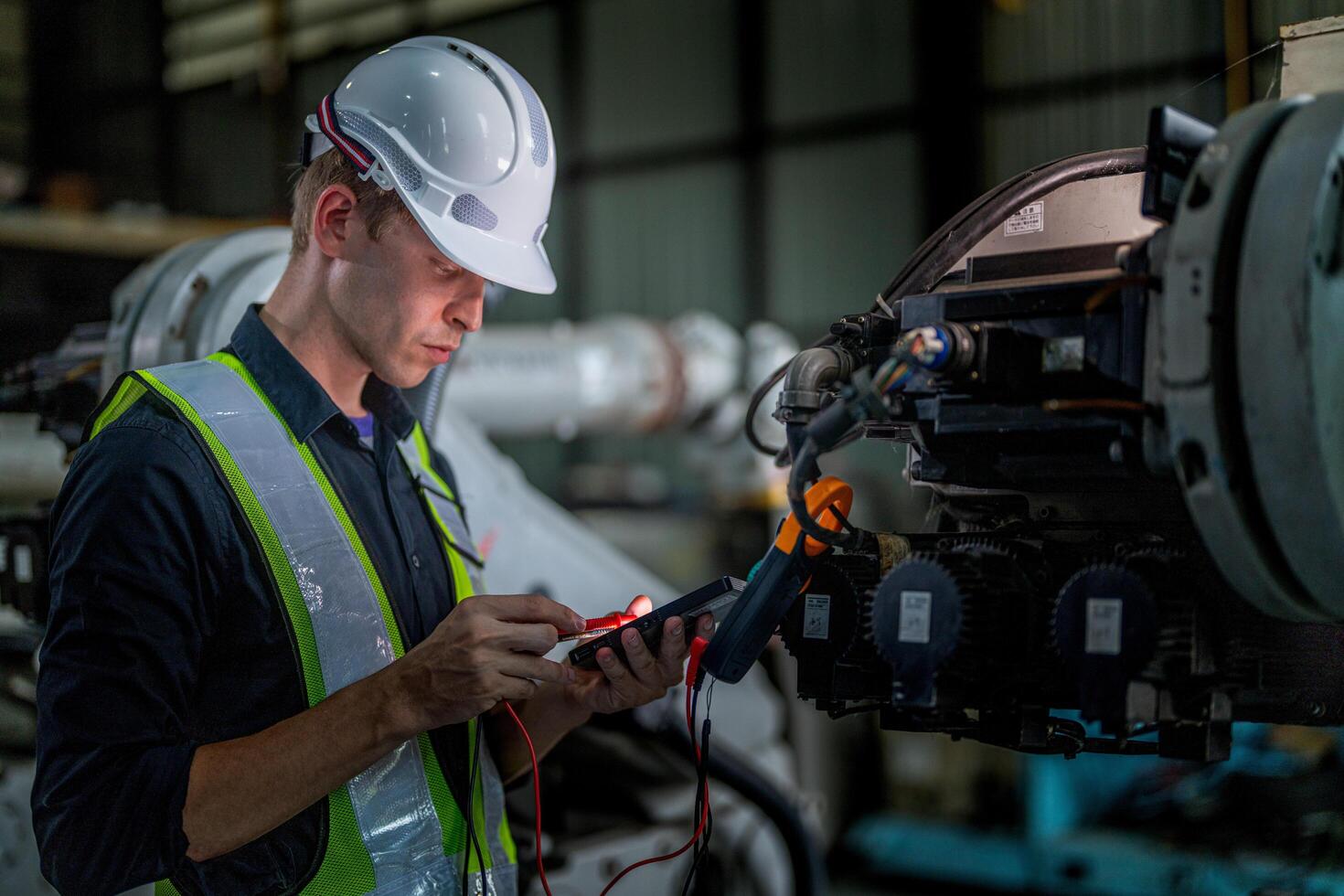 male engineer workers maintenance automatic robotic arm machine in a factory. worker checking and repairing automatic robot hand machine. photo