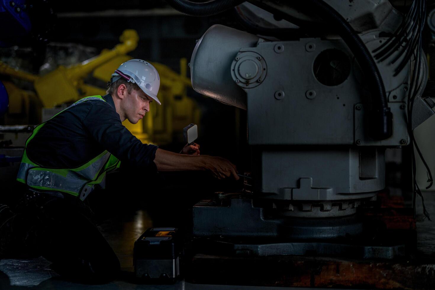 male engineer workers maintenance automatic robotic arm machine in a factory. worker checking and repairing automatic robot hand machine. photo