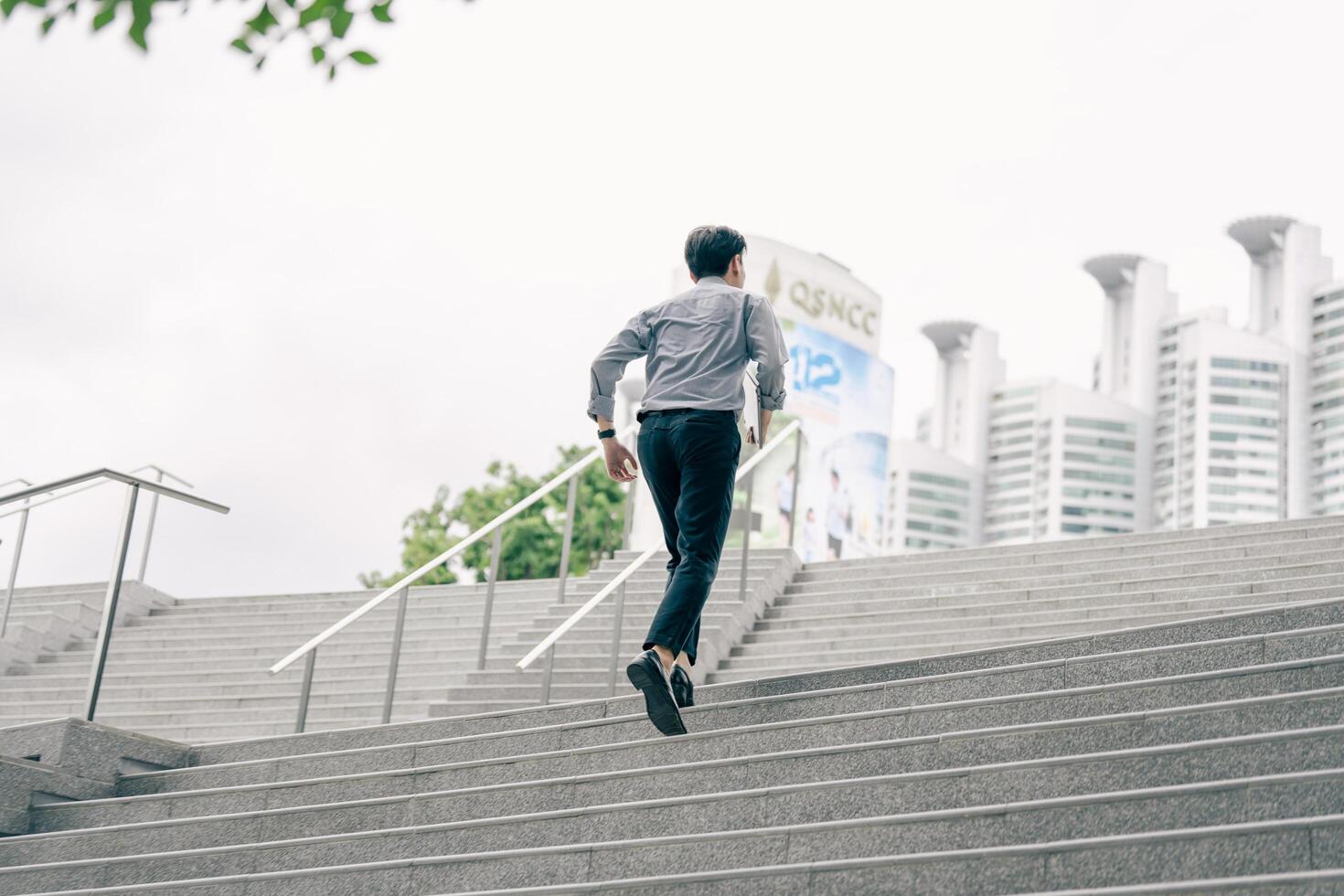 Asian businessman walking to work diligently and briskly in the morning in a big city. A man in a business suit, dressed in a smart suit, runs to work during rush hour in corridors and stairs. photo