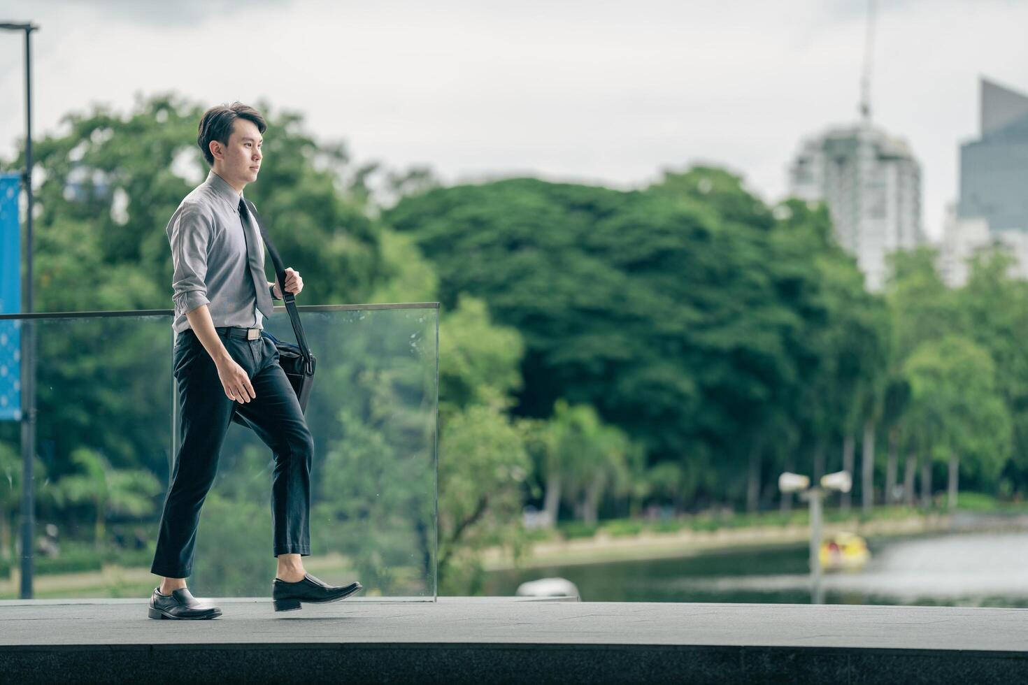 Asian businessman walking to work diligently and briskly in the morning in a big city. A man in a business suit, dressed in a smart suit, runs to work during rush hour in corridors and stairs. photo