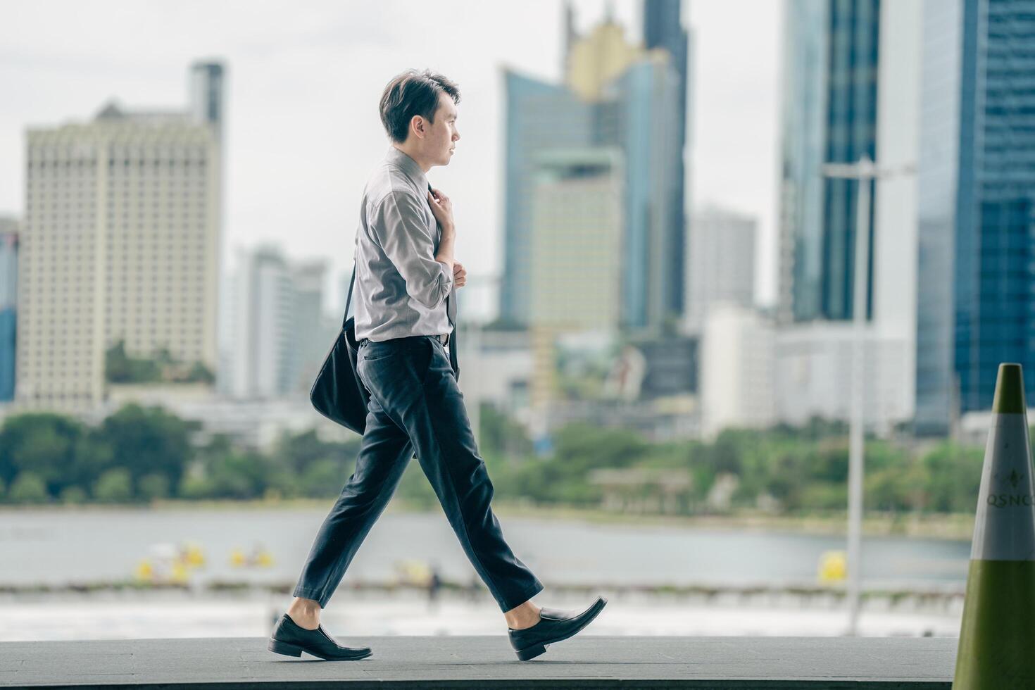 Asian businessman walking to work diligently and briskly in the morning in a big city. A man in a business suit, dressed in a smart suit, runs to work during rush hour in corridors and stairs. photo