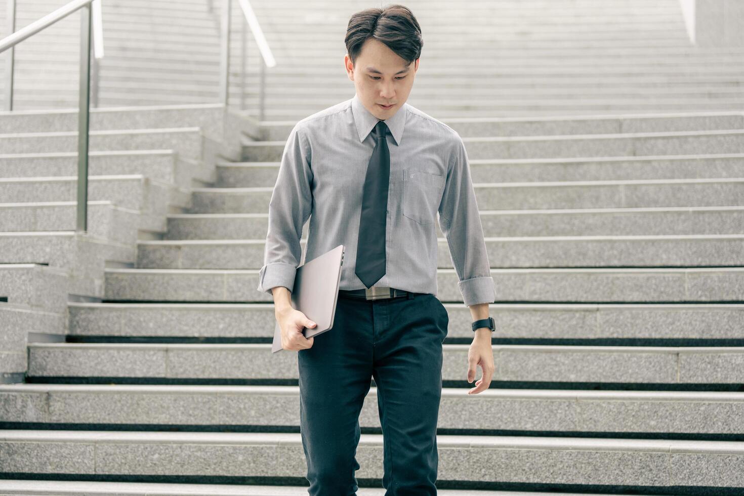 Asian businessman walking to work diligently and briskly in the morning in a big city. A man in a business suit, dressed in a smart suit, runs to work during rush hour in corridors and stairs. photo