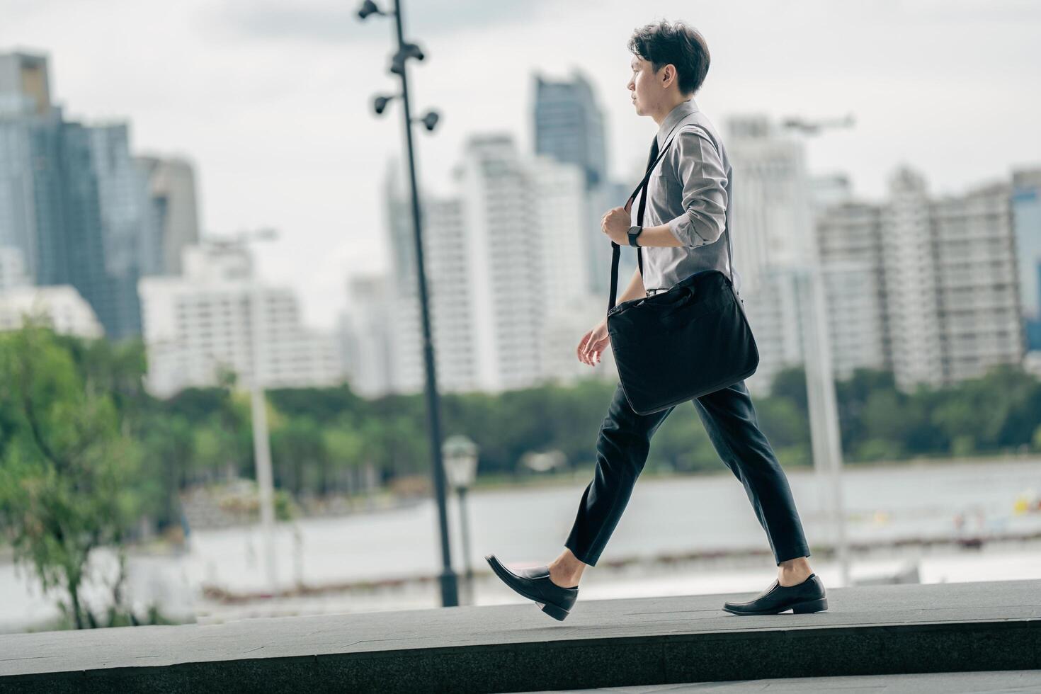 Asian businessman walking to work diligently and briskly in the morning in a big city. A man in a business suit, dressed in a smart suit, runs to work during rush hour in corridors and stairs. photo