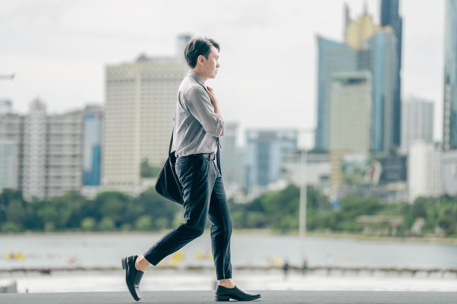 Asian businessman walking to work diligently and briskly in the morning in a big city. A man in a business suit, dressed in a smart suit, runs to work during rush hour in corridors and stairs. photo